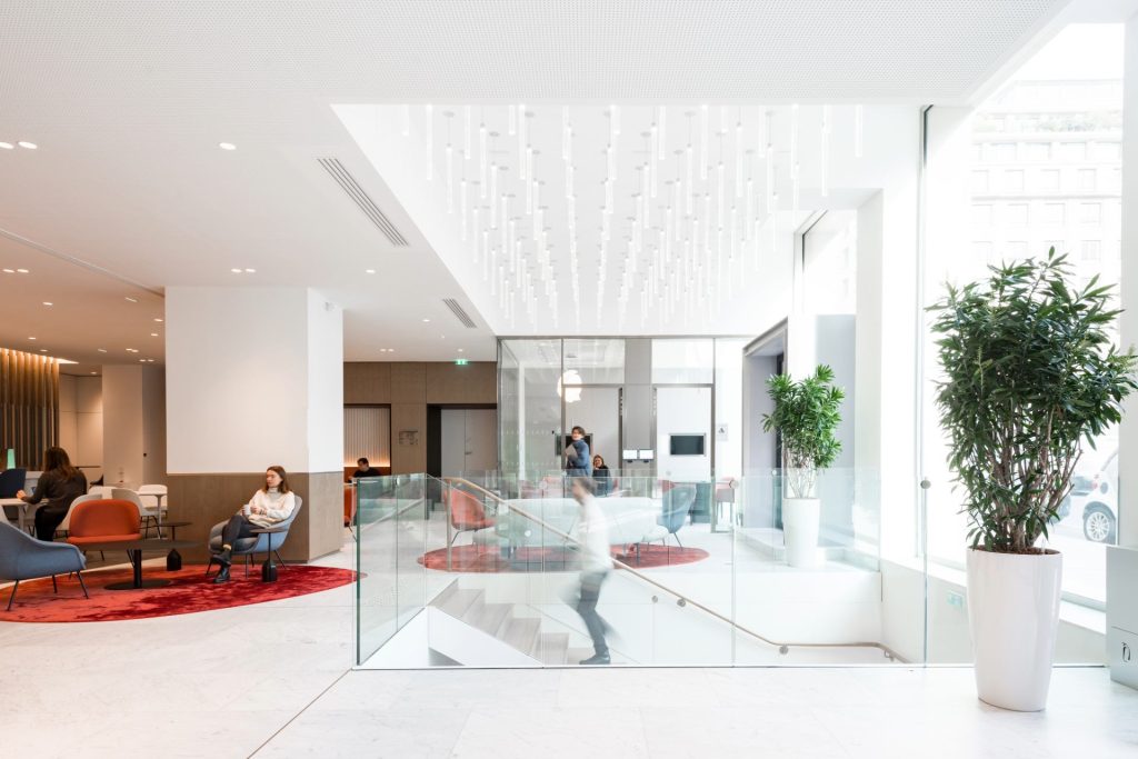 Etage chez Unofi, avec escalier central permettant de descendre à l'étage inférieur, espace très lumineux, luminaire décoratif au plafond au dessus de l'escalier
