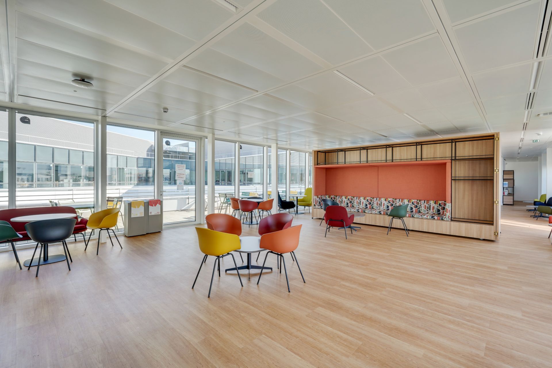 Espace de restauration, cafétéria, avec des chaises colorées, banquette à motifs