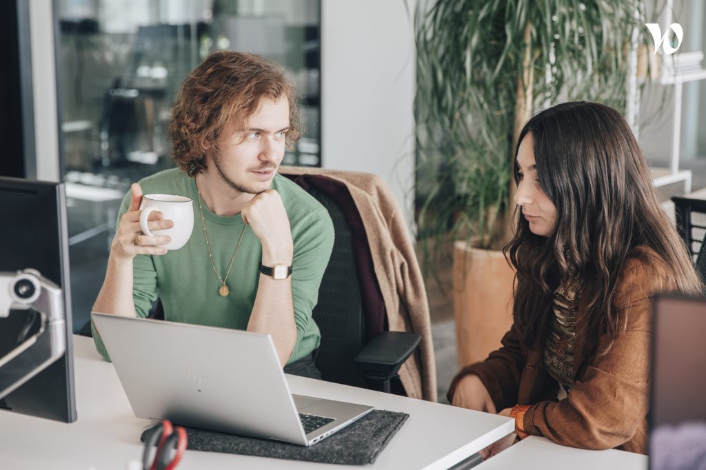 2 personnes qui échangent ensemble devant un PC portable