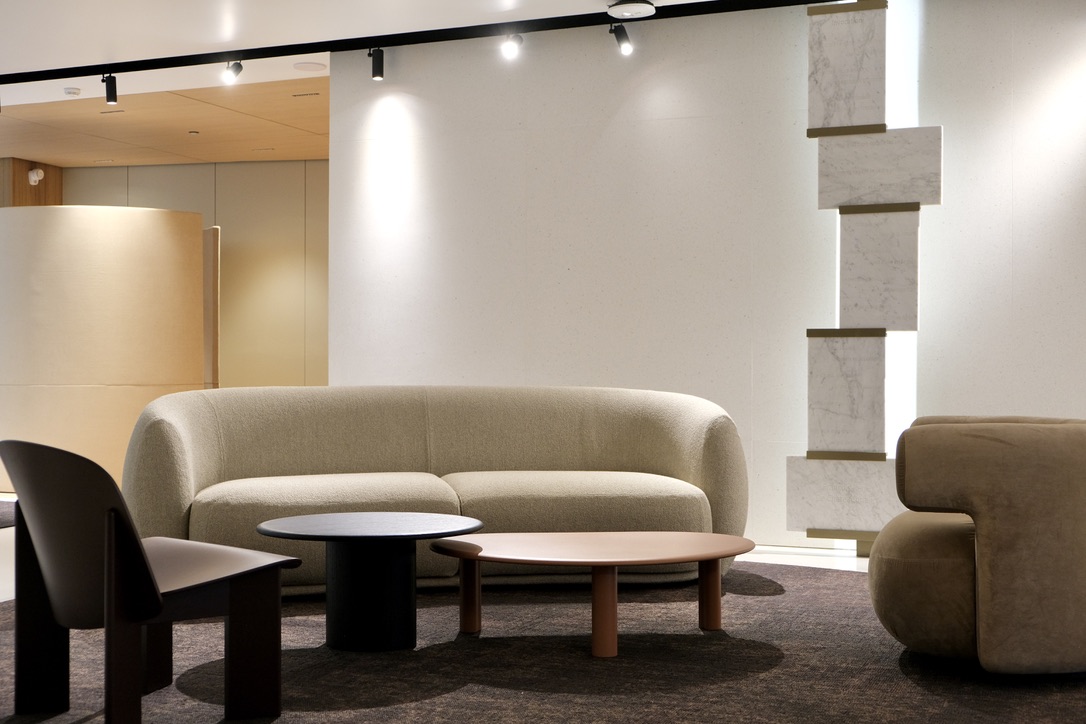 Salon avec canapé beige et table basse et fauteuil bas en bois foncé