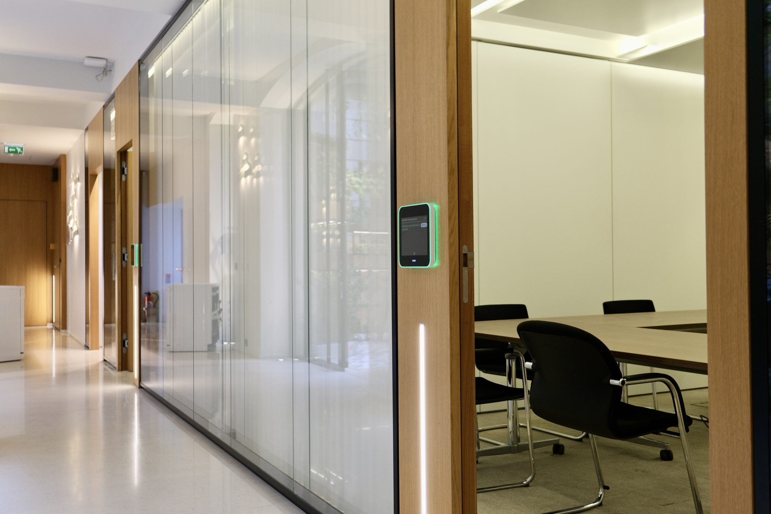 Allée dans les bureaux Meeschaert, vue d'une salle de réunion sur la droite