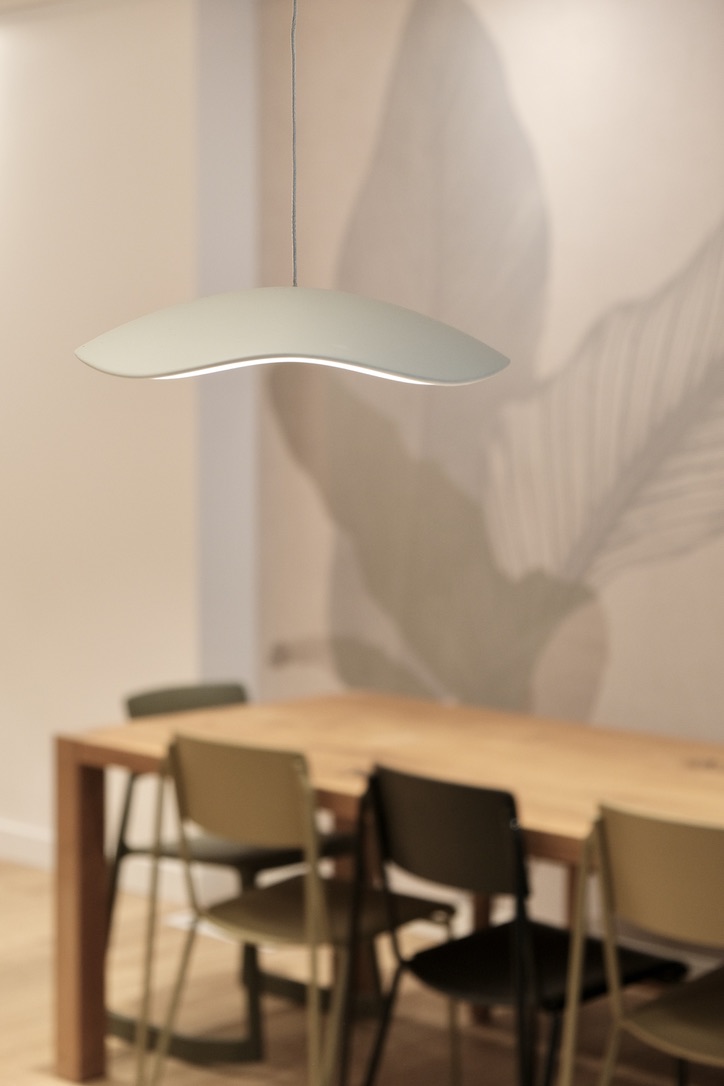 Zoom sur une luminaire avec table à manger derrière flootée
