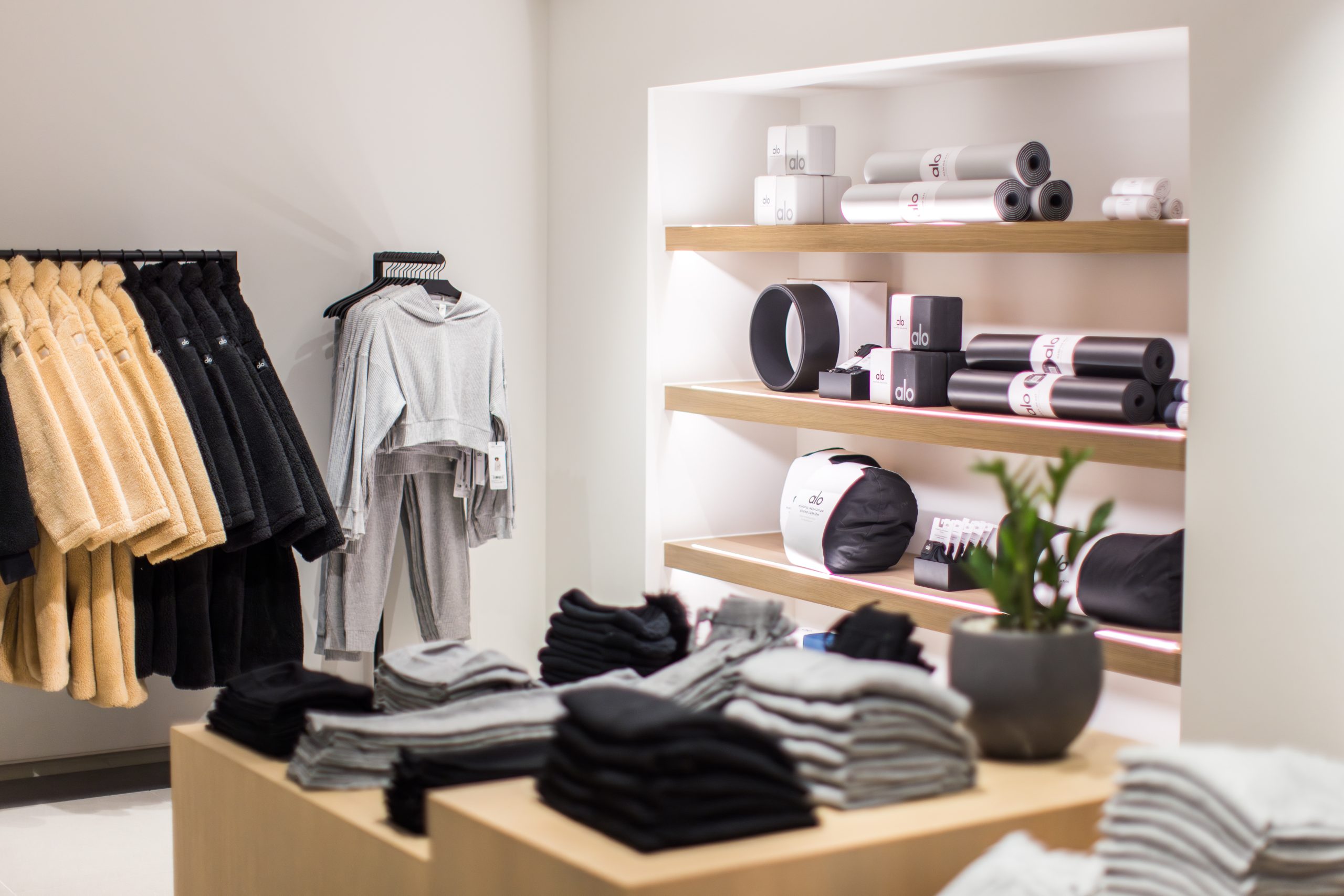 Etagère avec accessoires, dans une alcôve lumineuse. Présentoir à vêtement devant et portant sur le côté