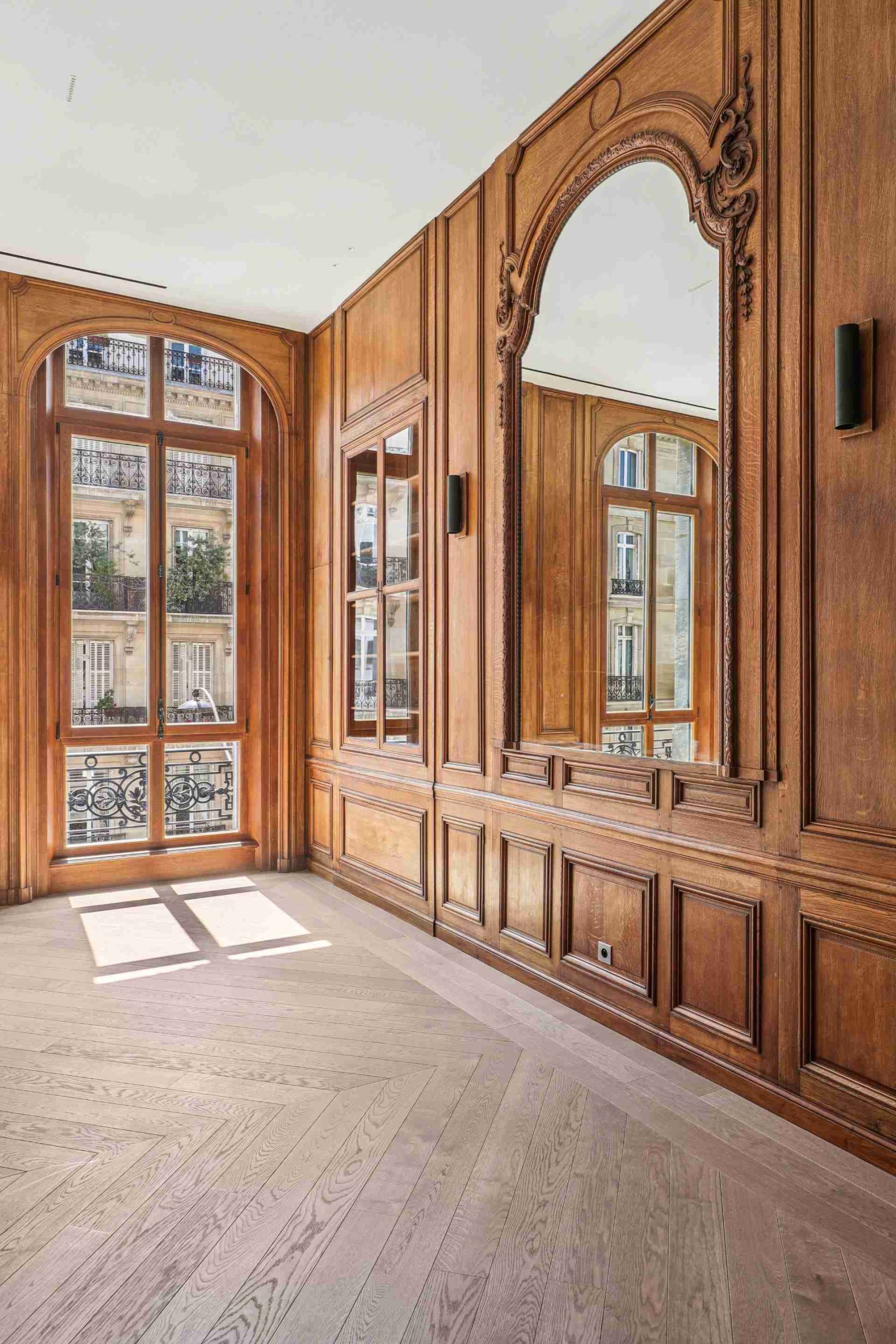 Mur en boiserie avec grand miroir, grande fenêtre