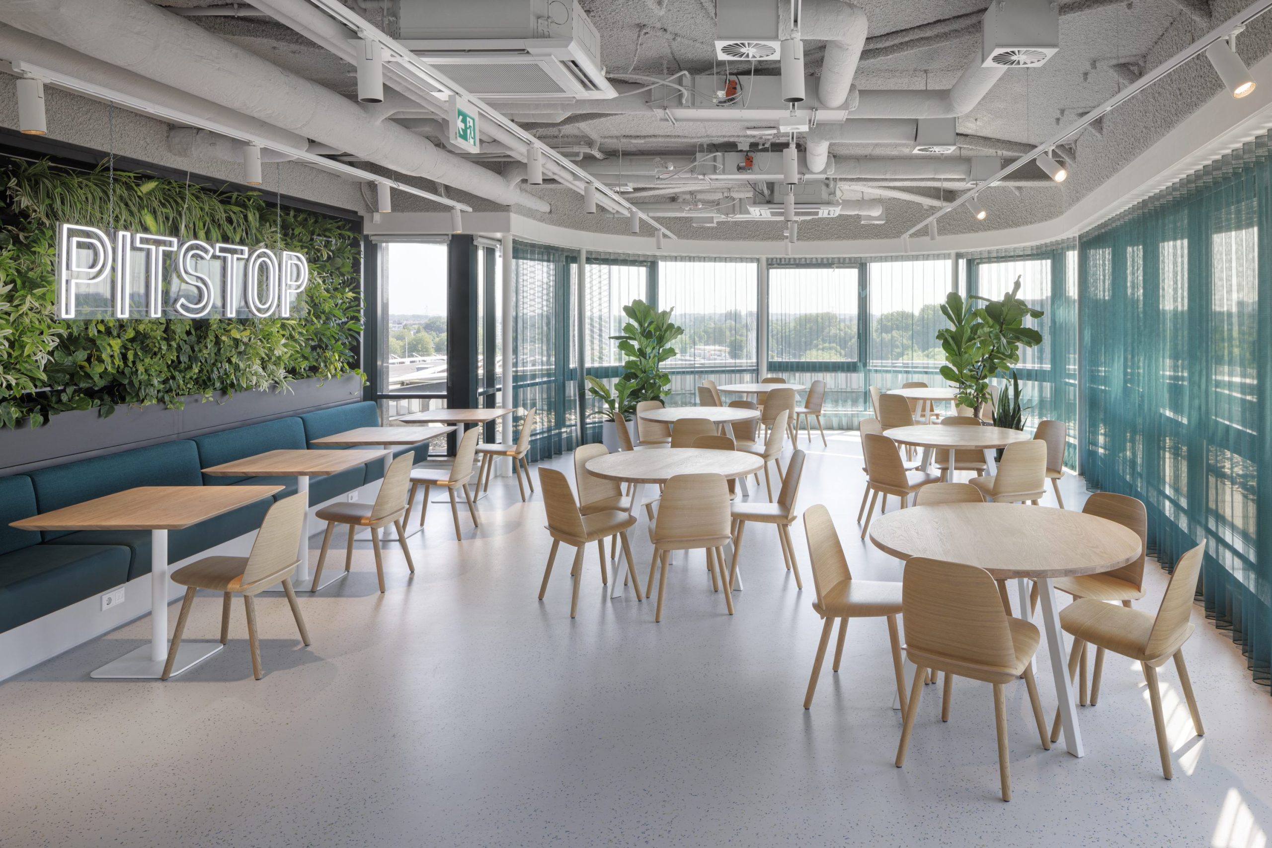 Espace de restauration, avec mur végétal décoratif, grande baie vitrée