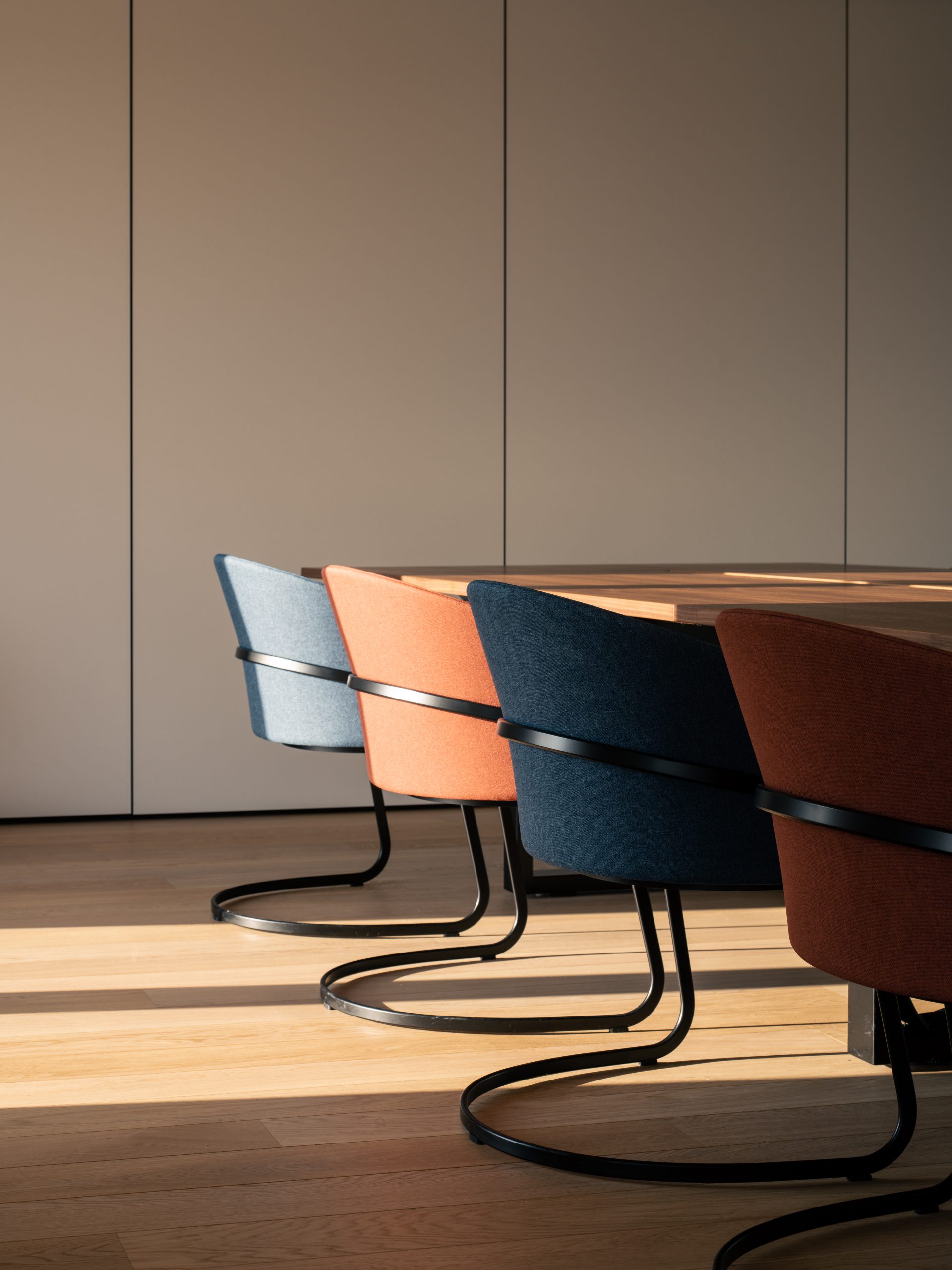 Salle de réunion avec des sièges de différentes couleurs (gris bleu, bleu foncé, orangé...)