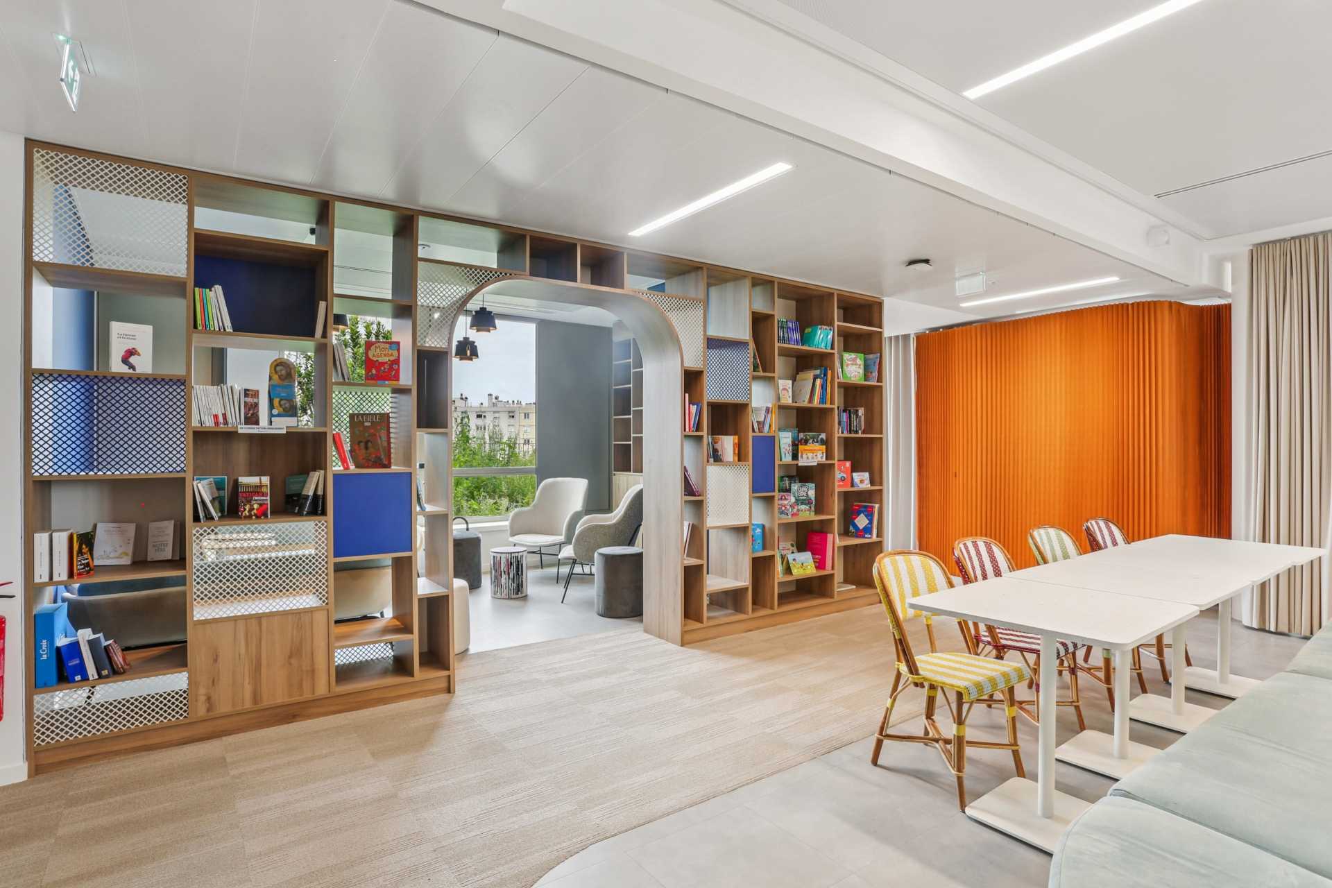 Espace convivial avec bibliothèque autour d'une arche