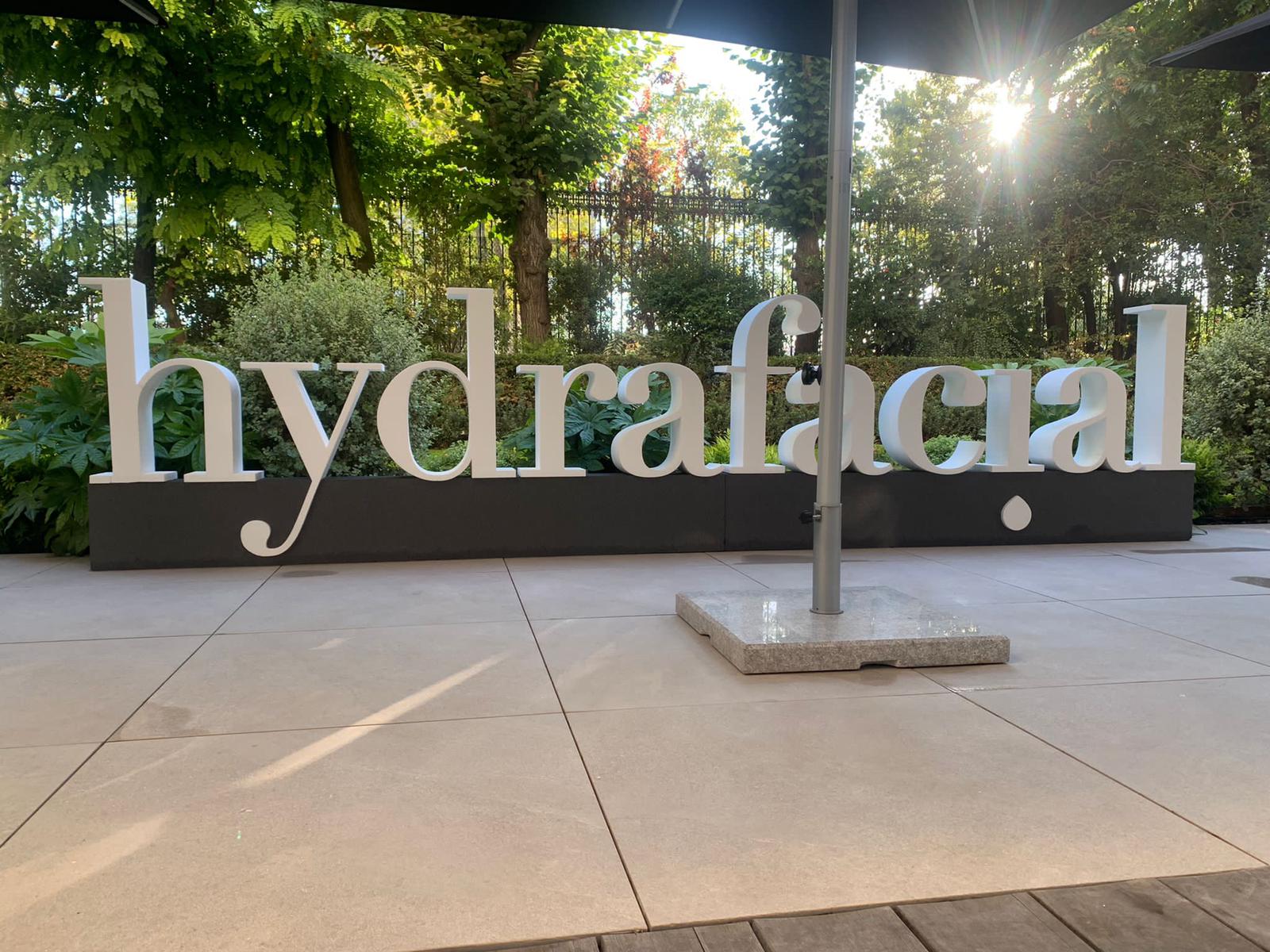 Logo Hydrafacial en volume sur une terrasse extérieur