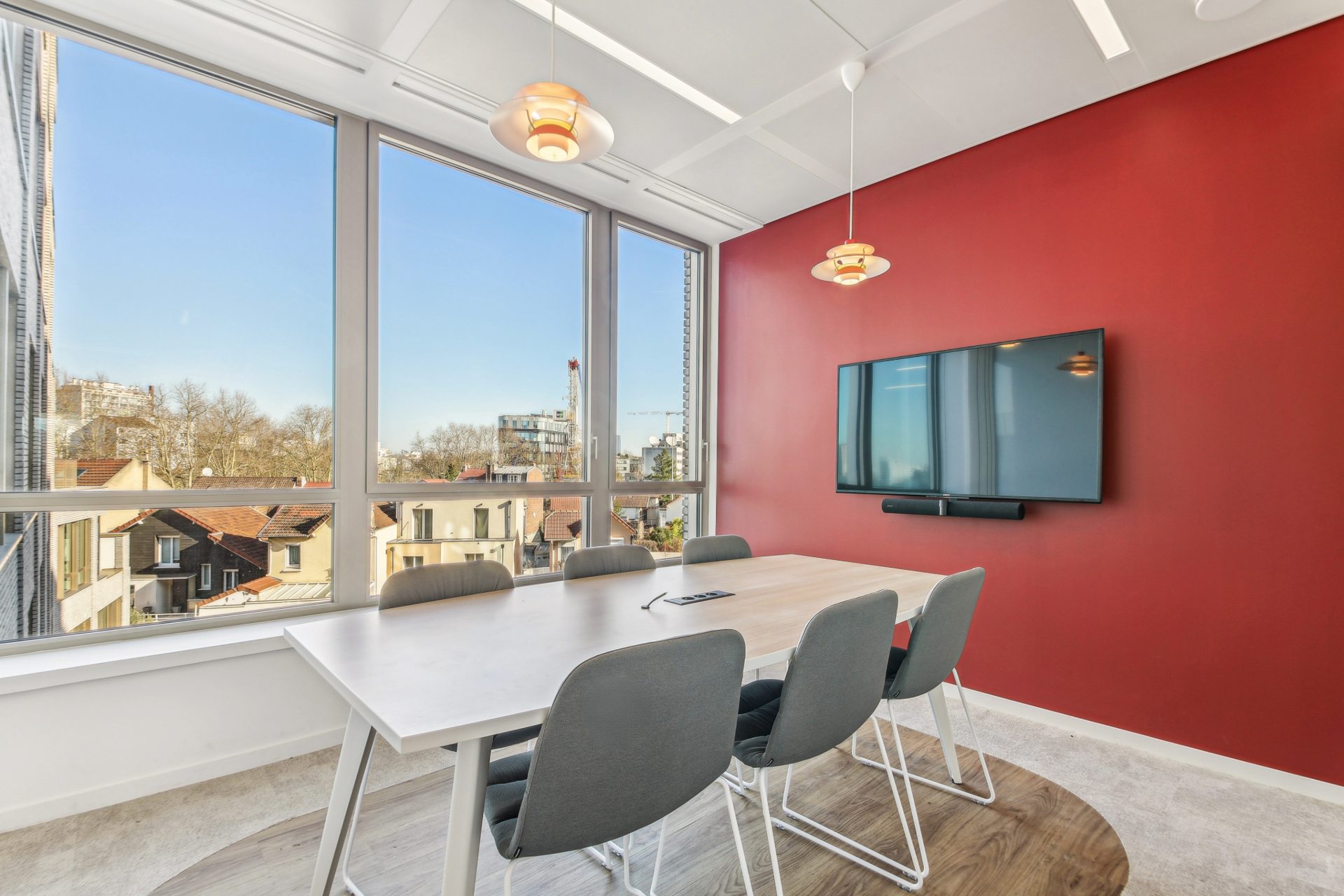 Salle de réunion avec baies vitrées et un mur rouge, chez Bayard, par Parella