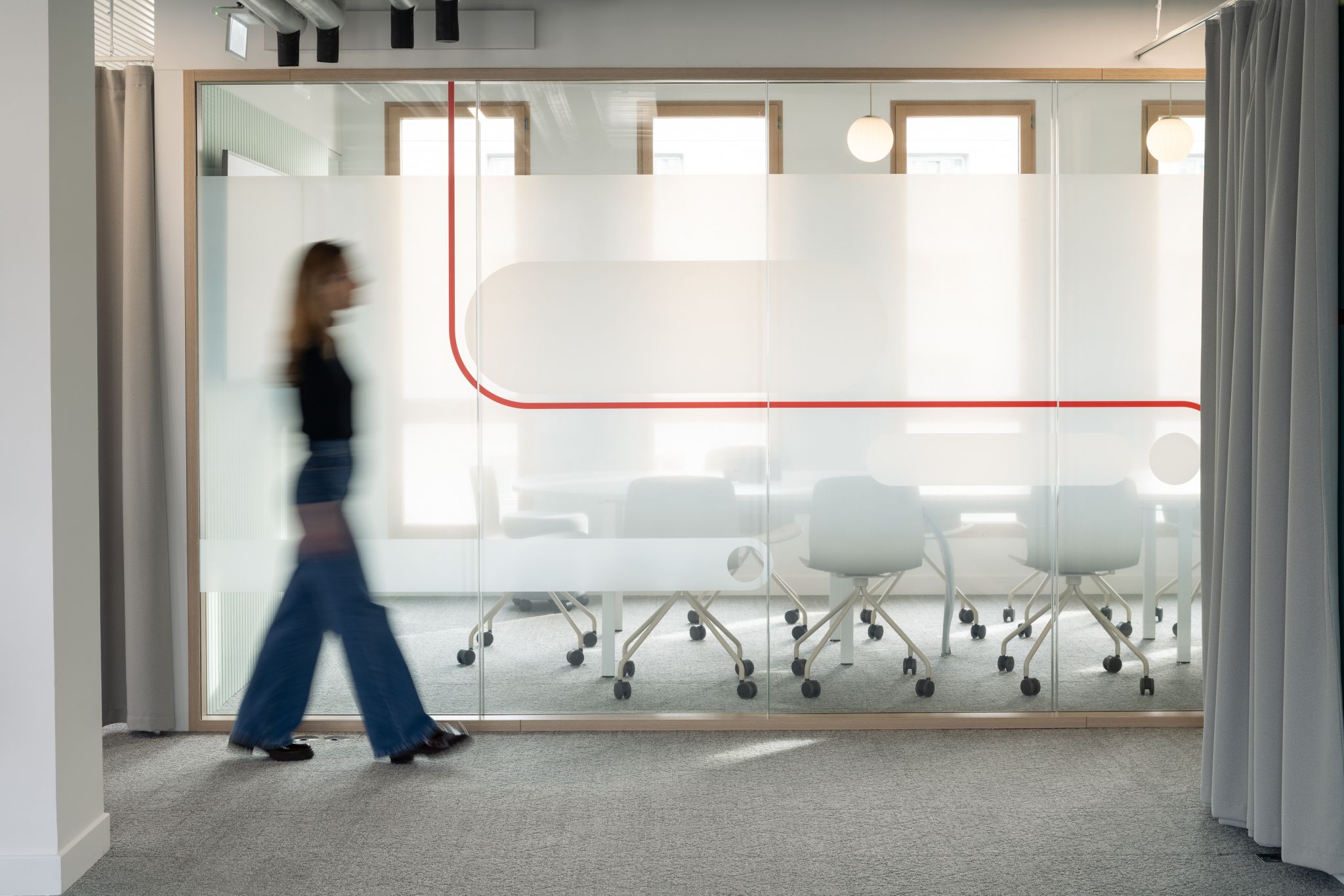 Vitrophanie semi opaque pour la confidentialité d'une salle de réunion, avec une ligne rouge rappelant la couleur de la marque