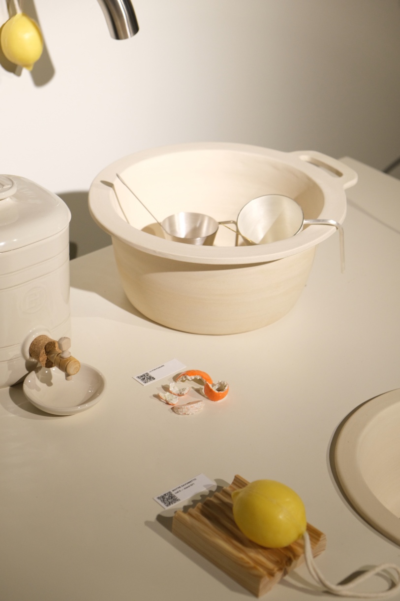 Juego de utensilios de cocina beige y naranja sobre tabla de cortar de madera sin tratar.
