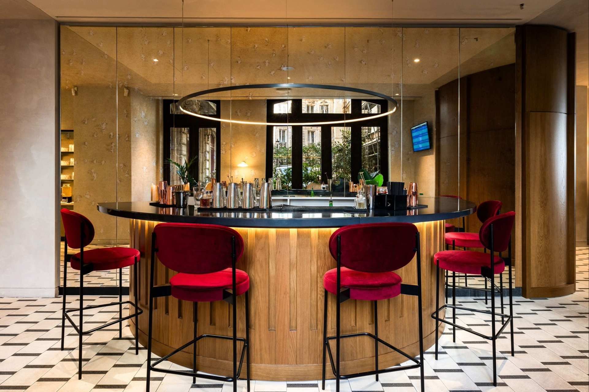 Vista desde el bar de madera marrón, asiento elevado metálico con cojín rojo.