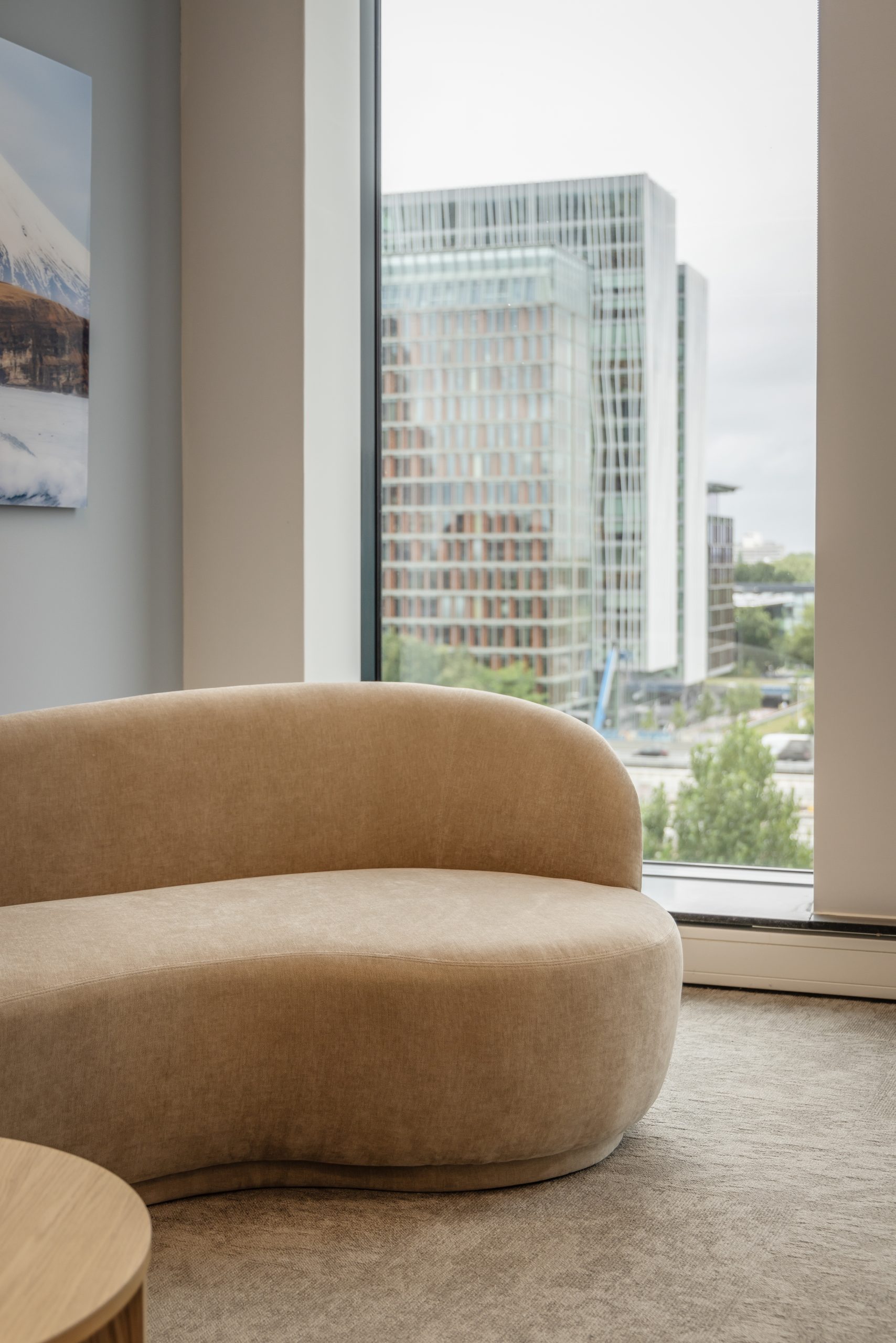 Visto en una ventana con un sofá beige delante y moqueta gris.