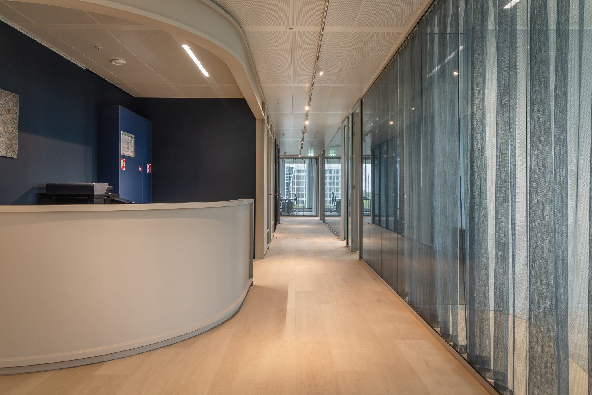 Visto en un pasillo con ventanas panorámicas, moqueta gris claro.